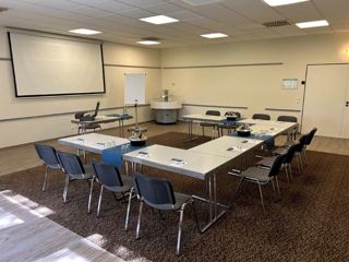 Konferenzraum II in U-Form mit Leinwand und Flipchart