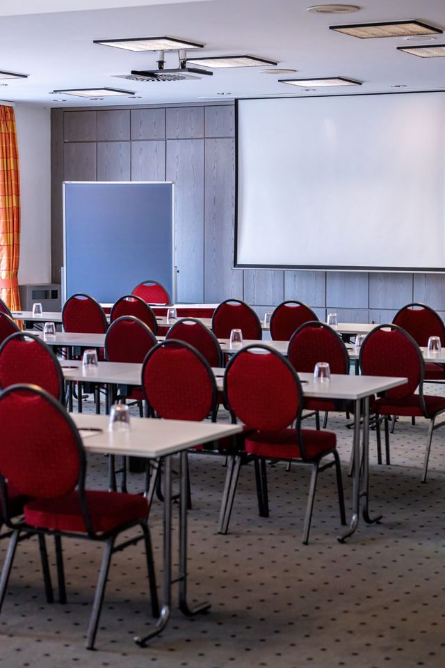 Derselbe Raumtyp aus anderer Richtung, mit Flipchart und raumhohen Vorhängen