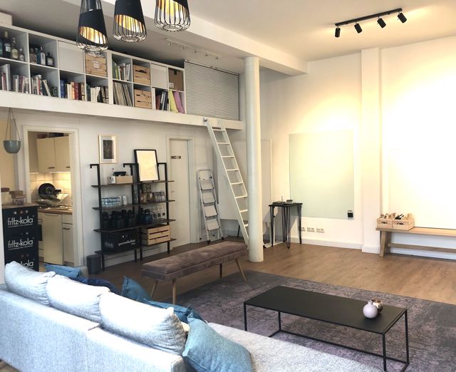 Blick in den Loft: Empore mit Bibliothek, Küchenzeile links, Whiteboardwand rechts