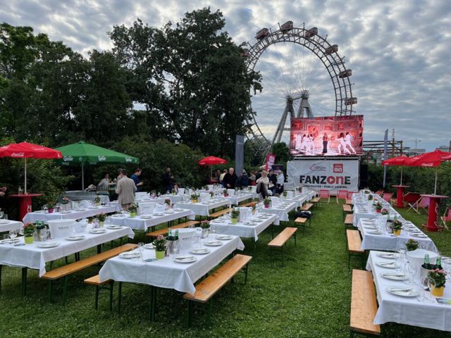 Festwiese mit eingedeckten Biertischen und Blick aufs Riesenrad