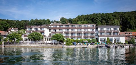 Das Seehotel Leoni vom Wasser aus, mit Seeterrasse, Liegewiese und eigenen Bootsstegen