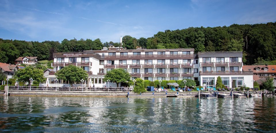 Das Seehotel Leoni vom Wasser aus, mit Seeterrasse, Liegewiese und eigenen Bootsstegen